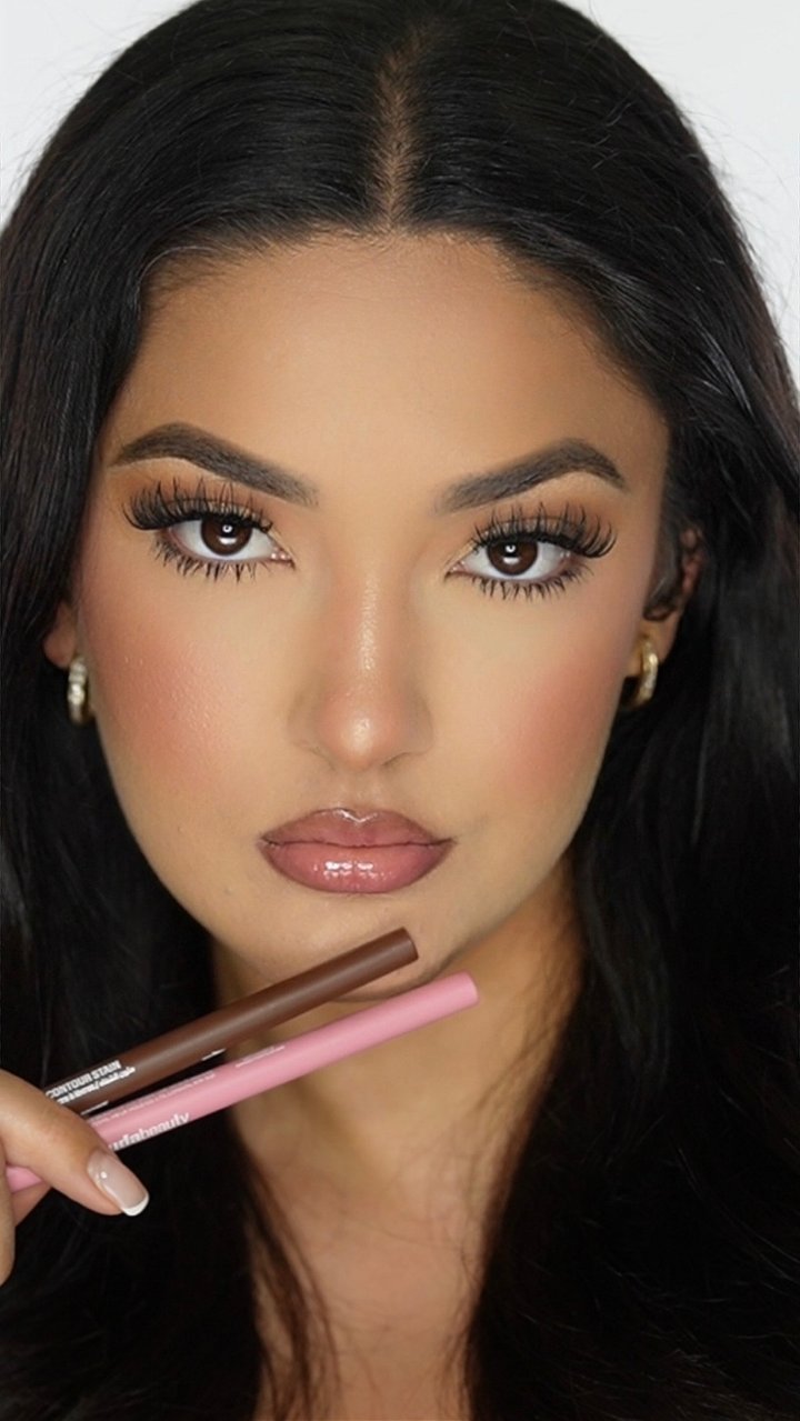 Bianca holding the lip liner duo under her chin, finished glam
